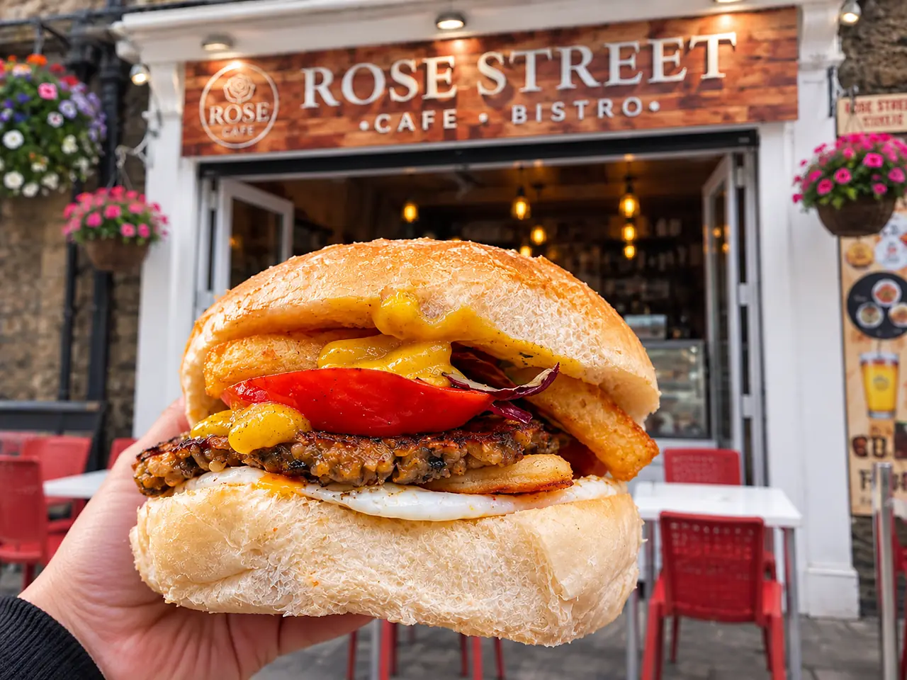 Burger with fried egg in front of the shopfront