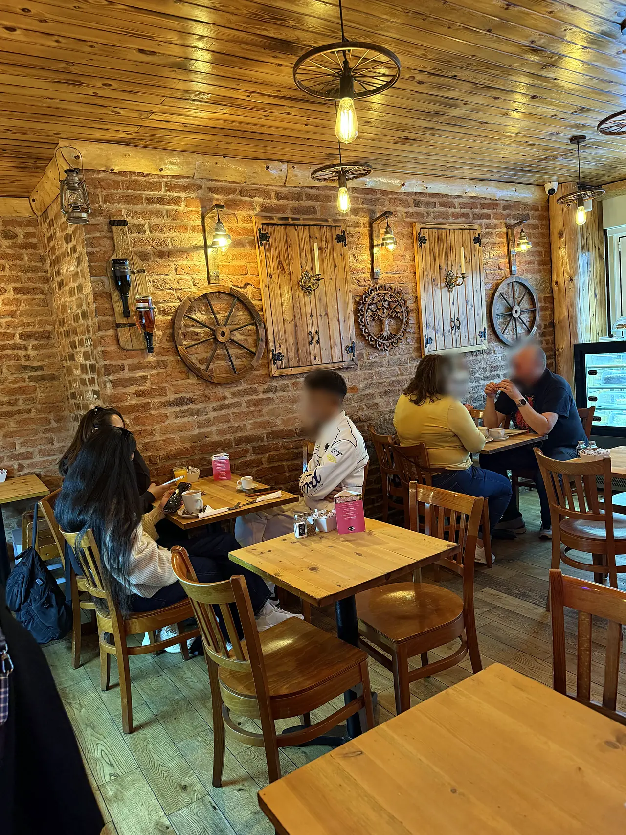 Exposed brick wall with wagon wheels and wooden tables